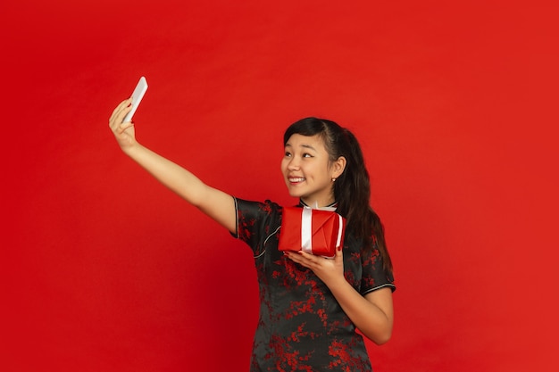 해피 중국 설날. 빨간색 배경에 고립 된 아시아 젊은 여자의 초상화