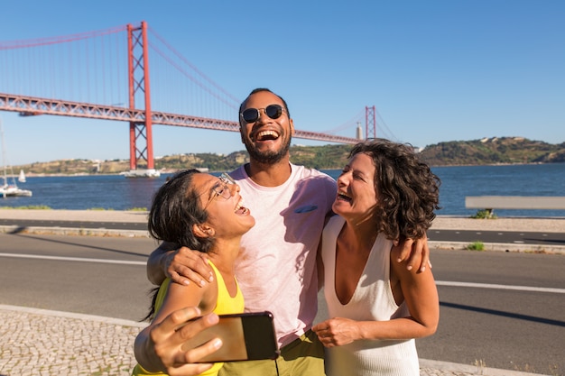 Happy close friends enjoying meeting and taking group selfie