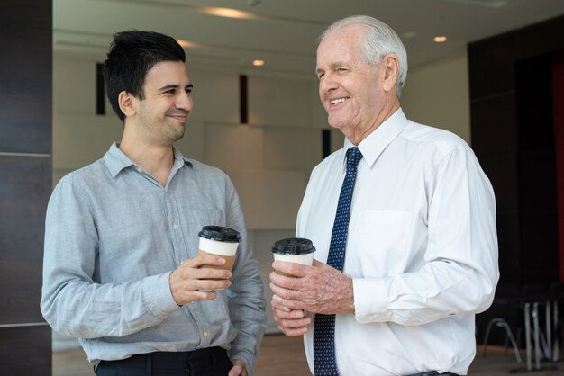 Happy colleagues with take away coffee