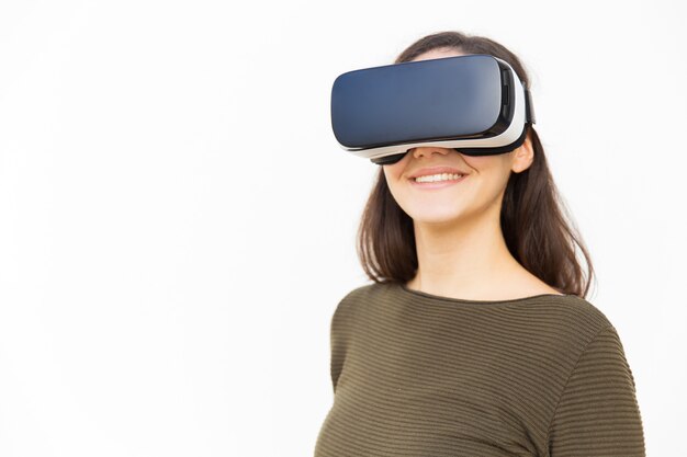 Happy content woman in VR headset smiling at camera