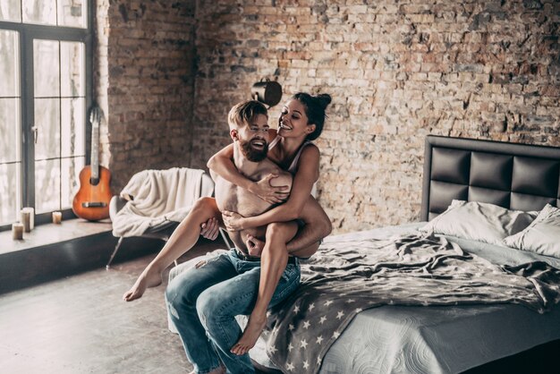 Happy couple. beautiful young couple having fun in bedroom at home