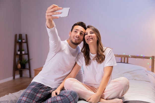 Happy couple in bed taking selfie