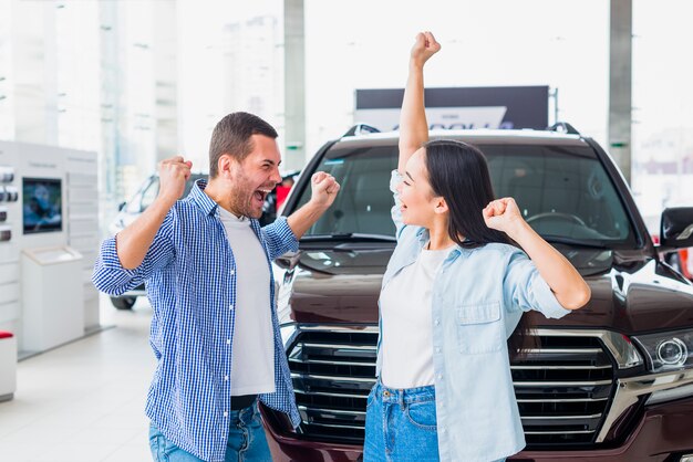 Happy couple at car dealership