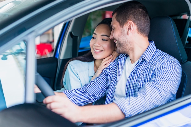 Happy couple at car dealership