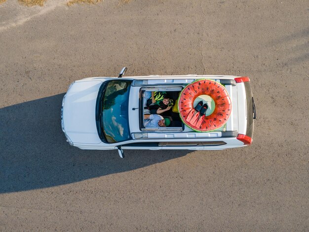 Happy couple in car overhead view car travel to sea concept sunroof