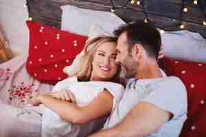Free photo happy couple celebrating christmas in bed