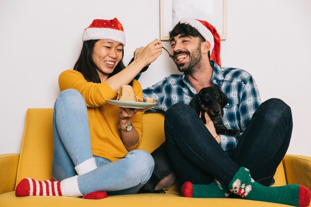 Счастливая пара празднует Рождество на диване