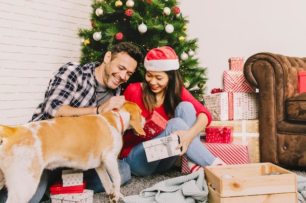 Happy couple celebrating christmas with dog
