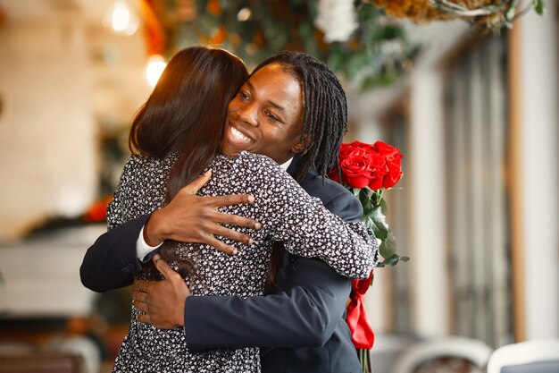 Happy couple celebrating their engagement in a cafe and hugging tightly