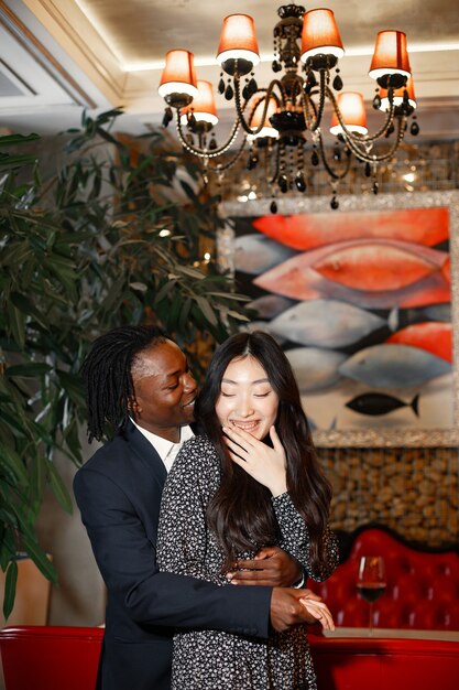 Happy couple celebrating their engagement in a cafe and hugging tightly