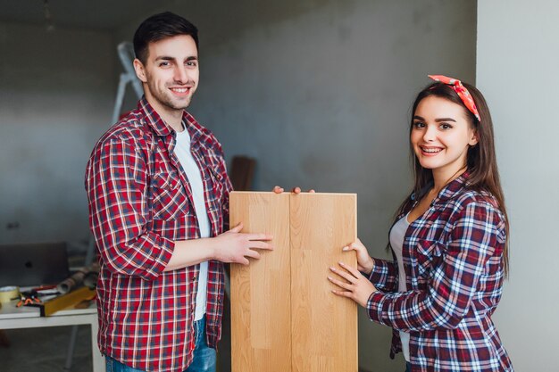 Happy couple choosing laminate flooring for new apartaments