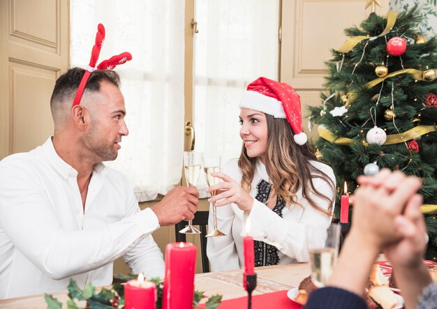Happy couple clanging glasses at festive table