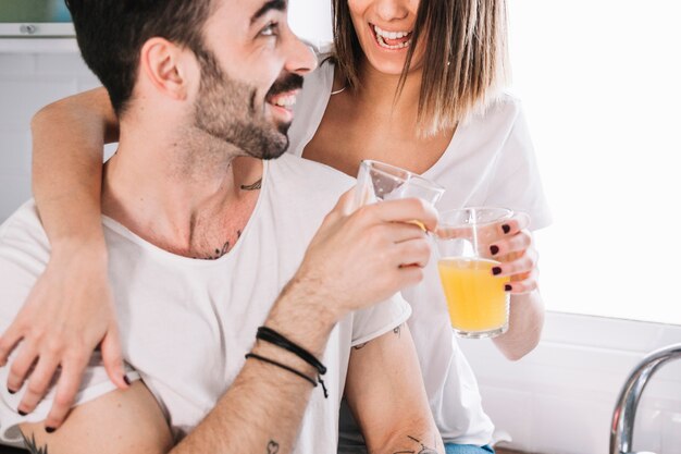 Happy couple clinking glasses in kitchen
