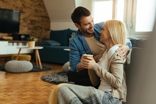 Happy couple communicating while sitting close to each other in the living room