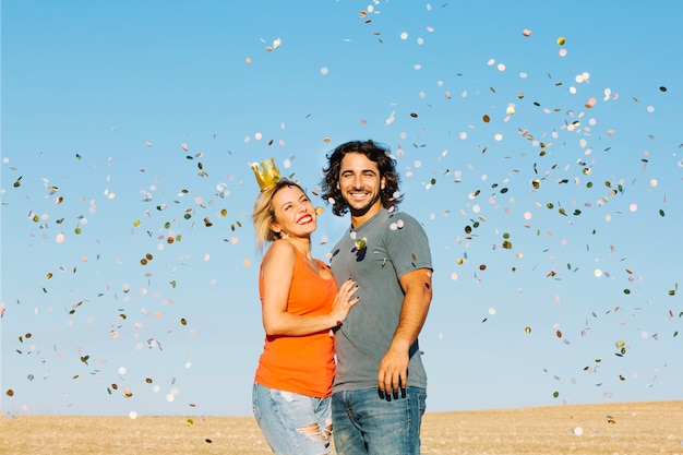 Free photo happy couple under confetti shower