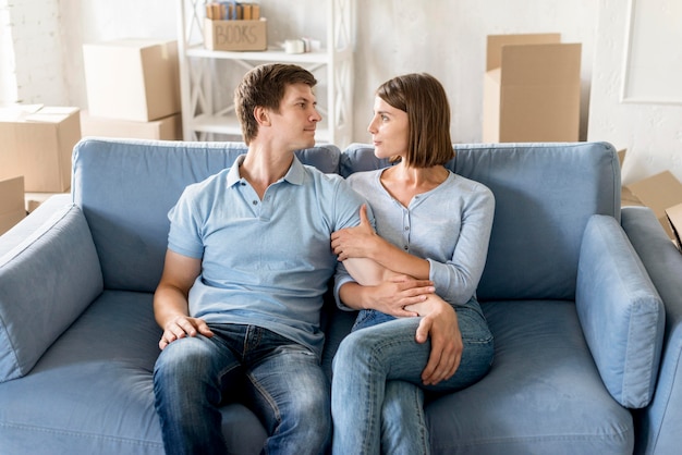 Happy couple on couch while packing to move house