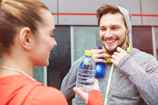 Happy couple drinking water after exercise