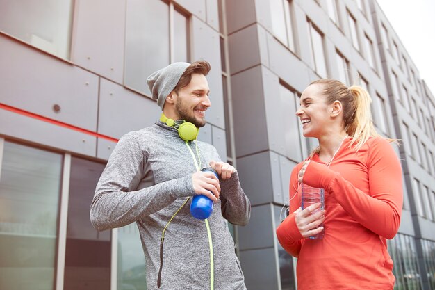 Happy couple drinking water after exercise