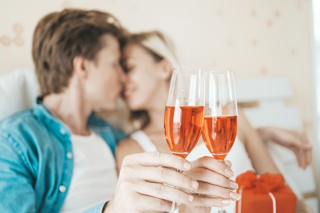 Free photo happy couple drinking wine in the bedroom