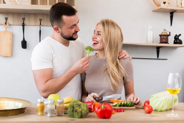 Happy couple eating broccoli