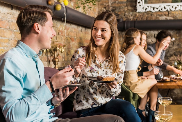 Free photo happy couple eating pizza slice on plate