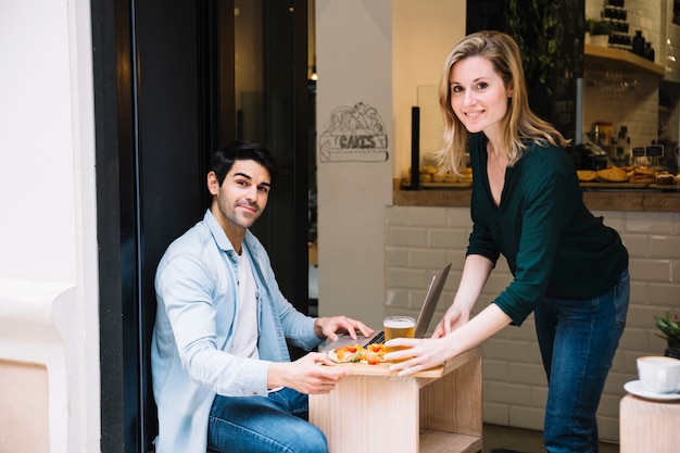 Free photo happy couple eating in restaurant together