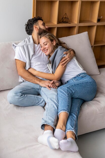 Happy couple embraced on the sofa at home