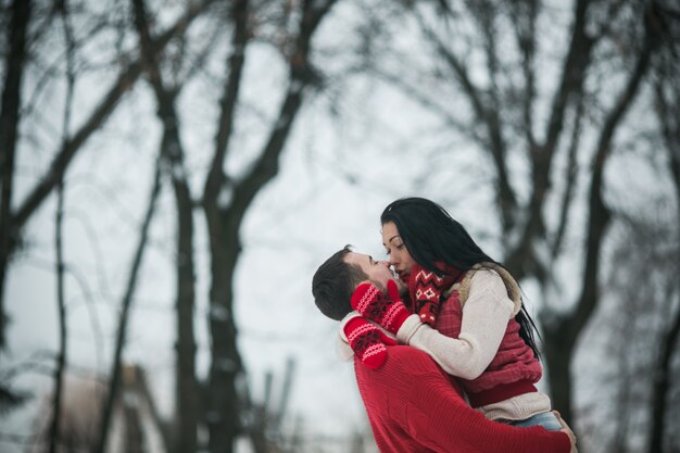 Happy couple embracing in winter woods