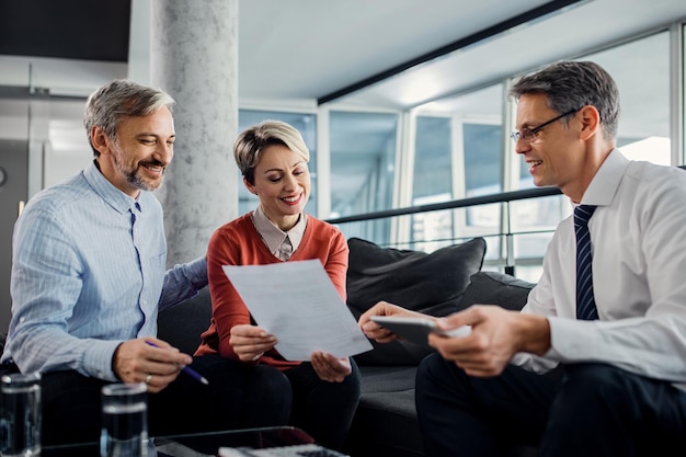 Free photo happy couple and financial advisor going through plans during the meeting