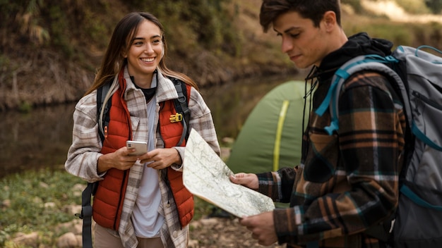 Happy couple in the forest looking on a map