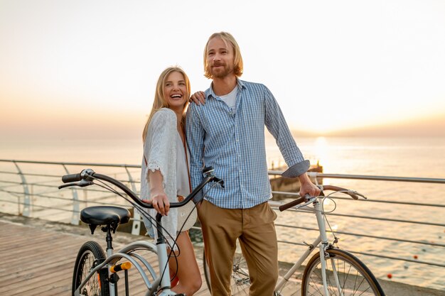 happy couple of friends traveling in summer on bicycles