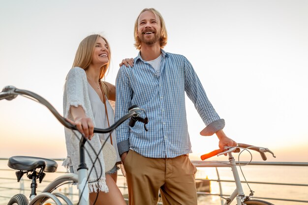 happy couple of friends traveling in summer on bicycles