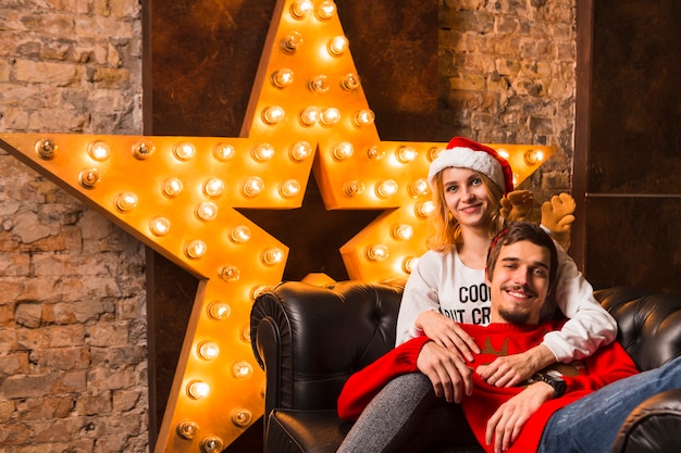 Free photo happy couple in front of christmas star decoration