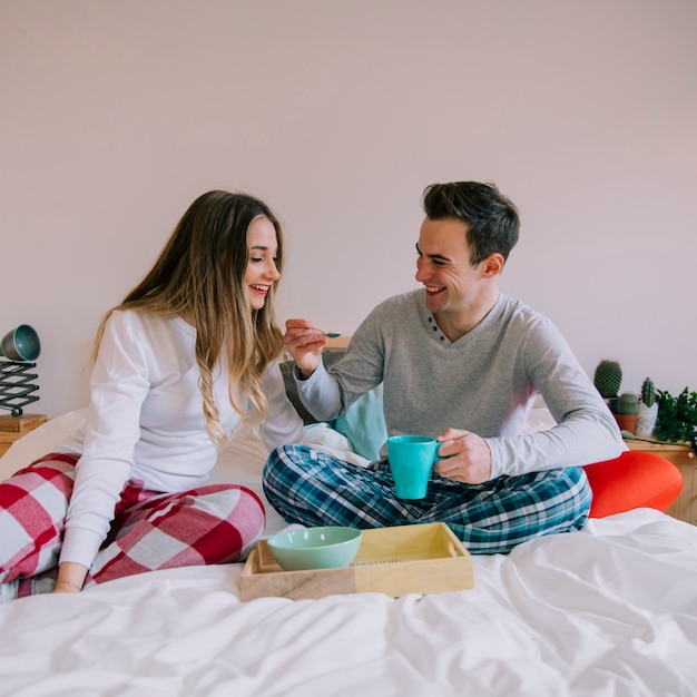 Happy couple having breakfast in bed