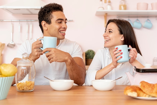 Free photo happy couple having breakfast in the kitchen