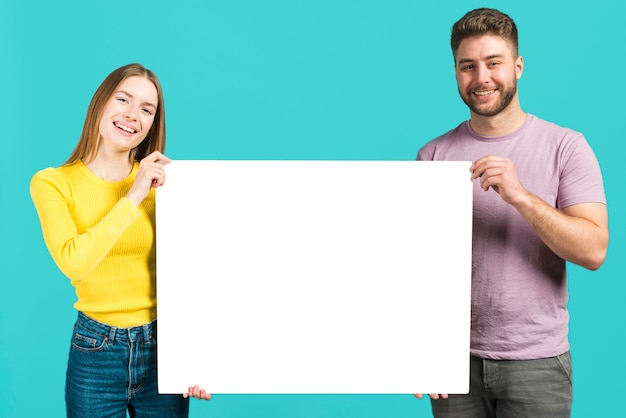 Happy couple holding blank sign