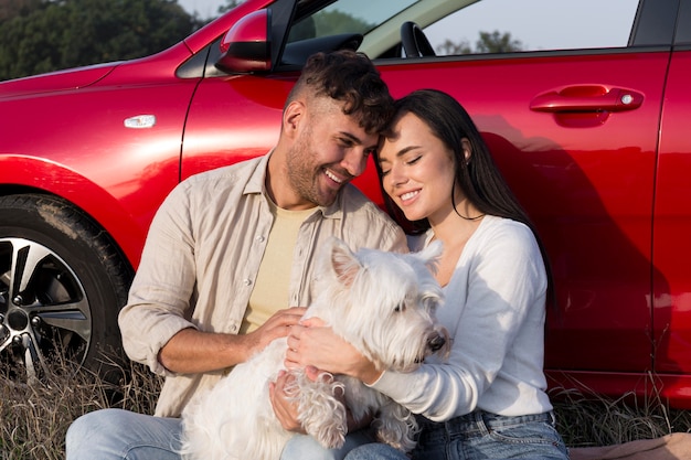 Happy couple holding dog medium shot