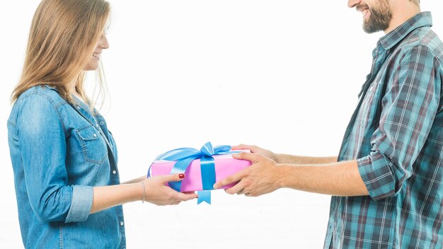 Happy couple holding gift box on white background