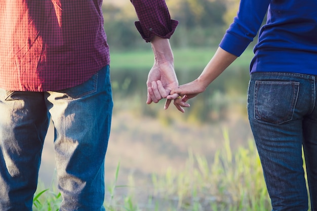 永遠の愛として一緒に手をつないでいる幸せな夫婦。