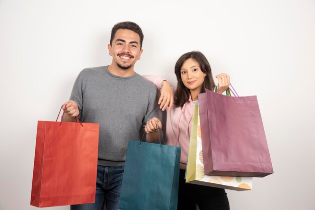 Happy couple holding shopping bags together.