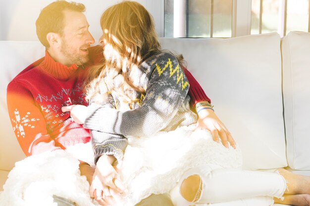 Happy couple hugging on sofa