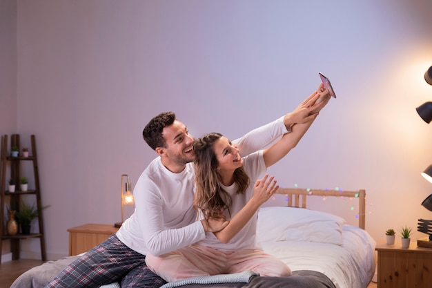 무료 사진 selfie를 복용하는 침대에서 행복 한 커플