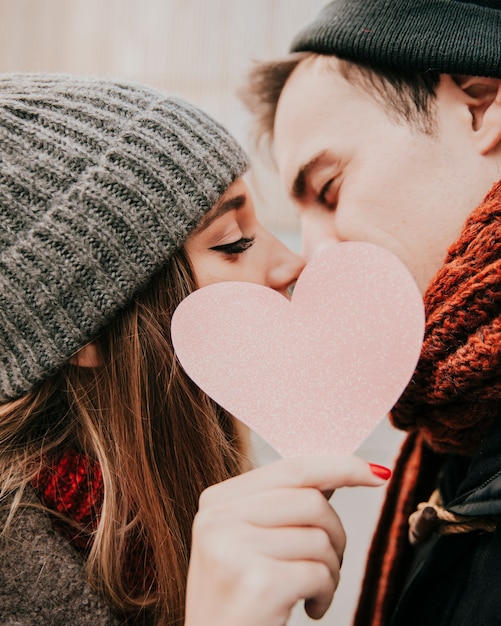 Free photo happy couple kissing behind heart