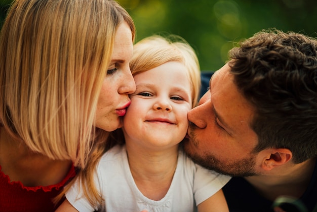 幸せなカップルが彼らの子供にキスをクローズアップ