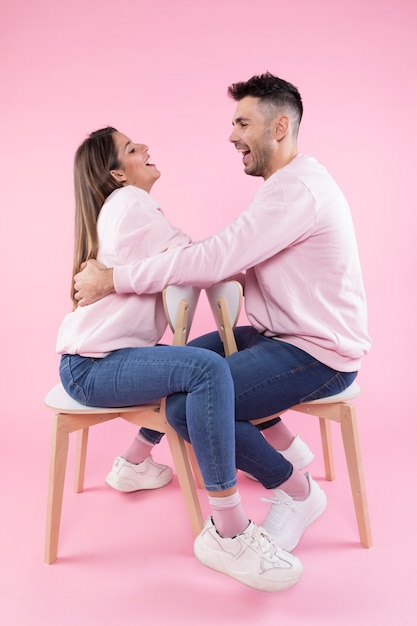 Free photo happy couple laughing on chairs