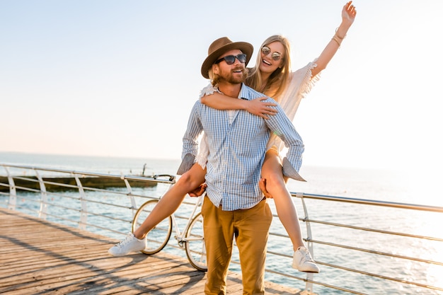 happy couple laughing traveling in summer by sea, man and woman wearing sunglasses