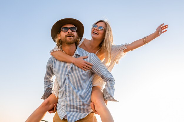 happy couple laughing traveling in summer by sea, man and woman wearing sunglasses