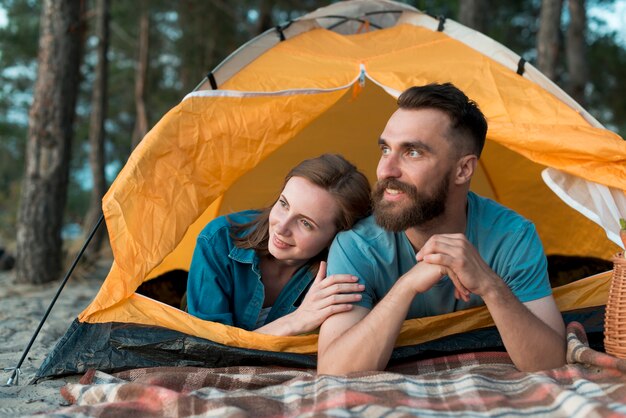 Happy couple laying down in the tent 