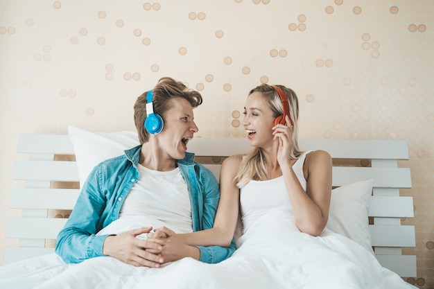 Счастливая пара слушает песню утром в спальне