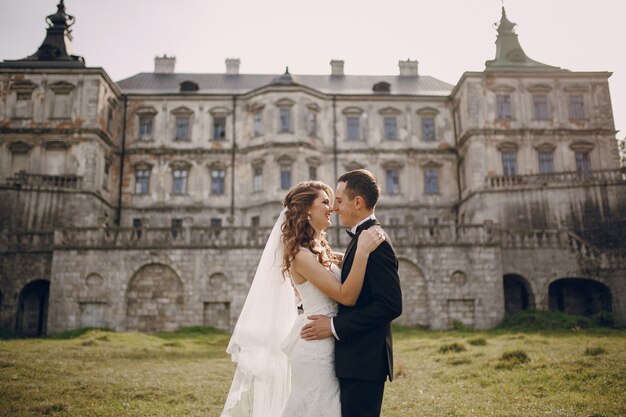 Happy couple looking at each other with old building background